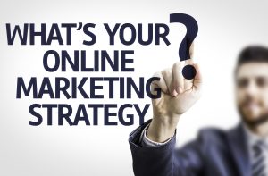 Geschäftsmann zeigt auf die Frage 'What's your online marketing strategy?' als Symbol für Online-Marketing-Beratung