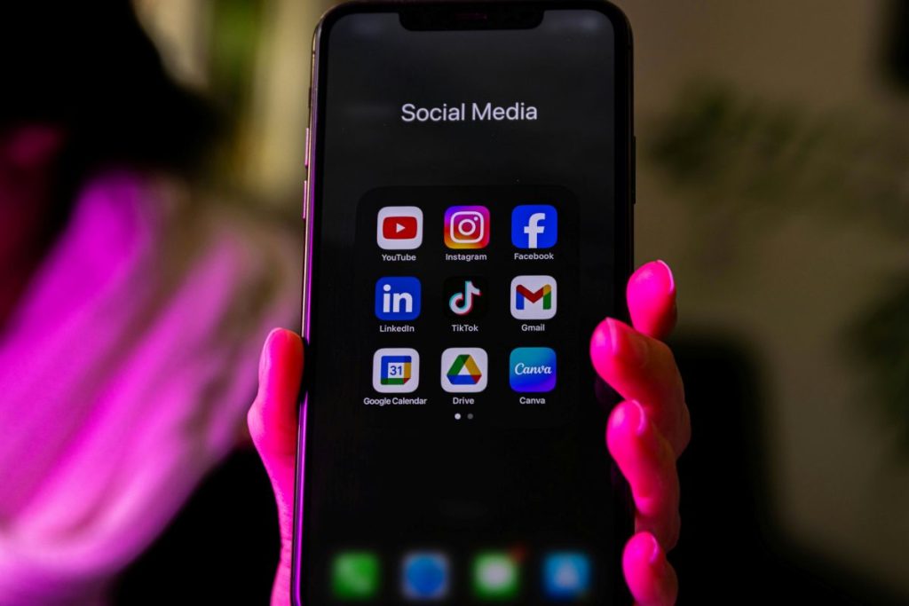 Smartphone das Facebook, Instagram, Youtube in einem Ordner Social Media hat.