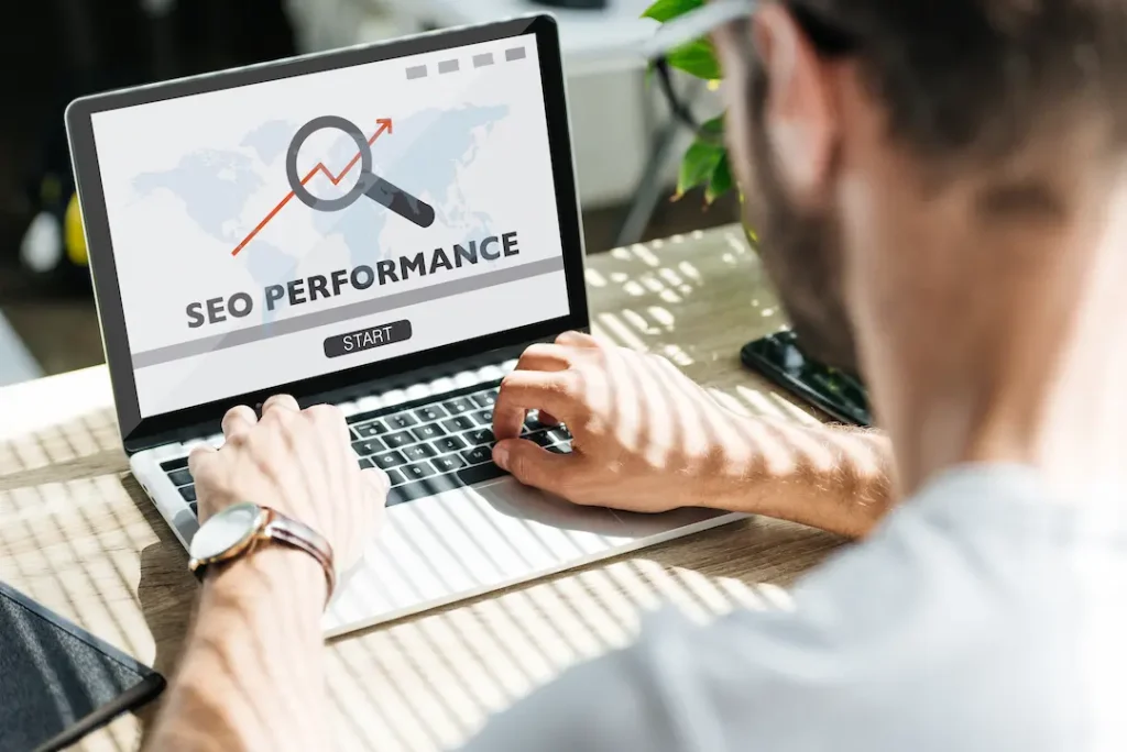 Person analysiert SEO-Performance auf einem Laptop mit Diagramm.
