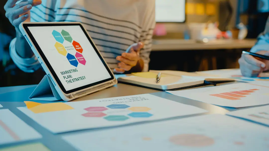 Tablet mit Marketingstrategie in Meeting-Situation
