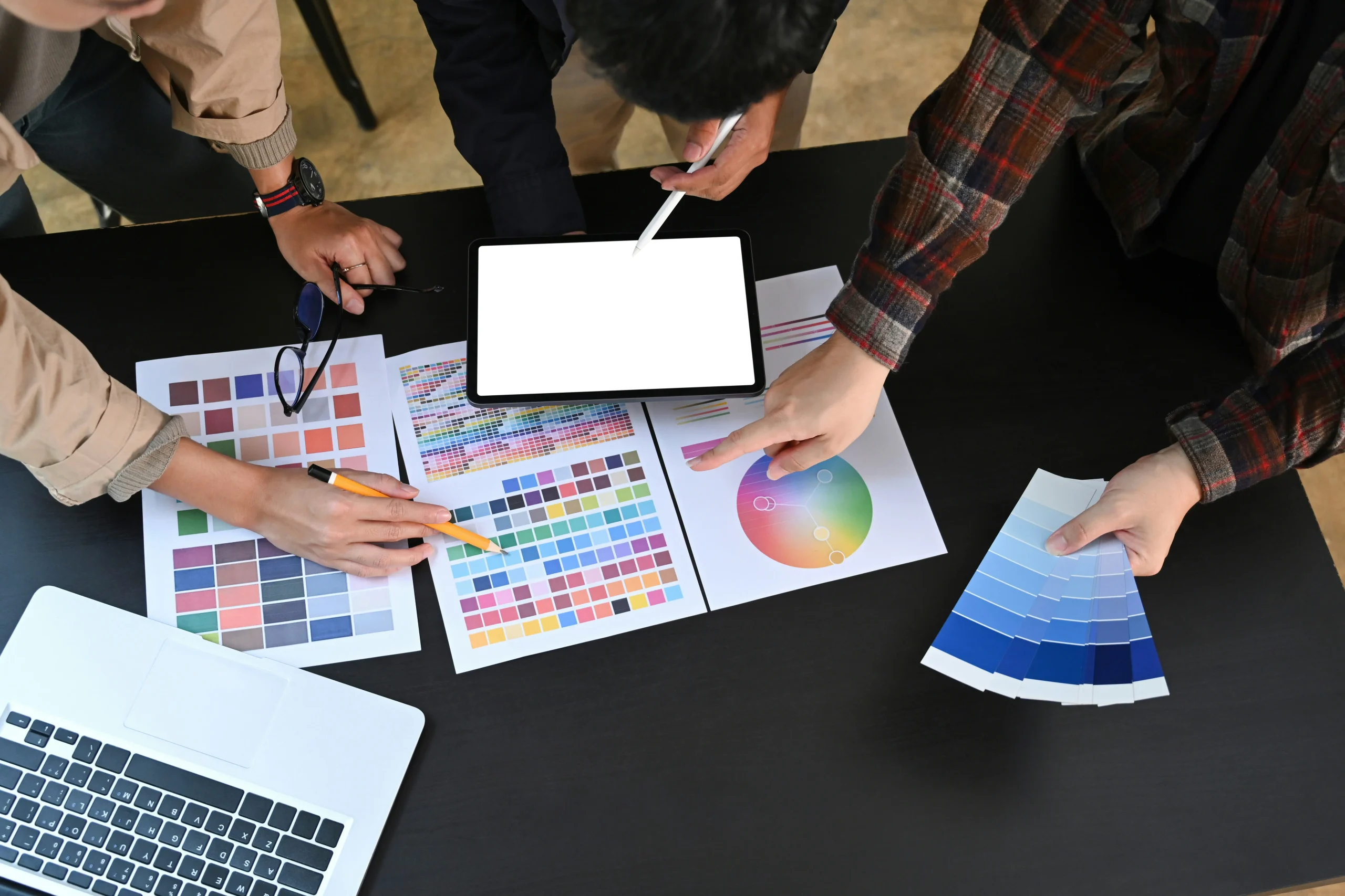 Kreativteam bespricht Farbkonzepte und Designentwürfe an einem Tisch.