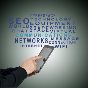 Hand tippt auf Tablet, umgeben von Schlagwörtern wie SEO, Cyberspace, Networks und Communications