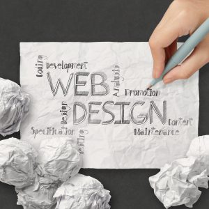 Web Design Konzept mit handgeschriebenen Begriffen wie Development, Coding und Analysis auf zerknülltem Papier