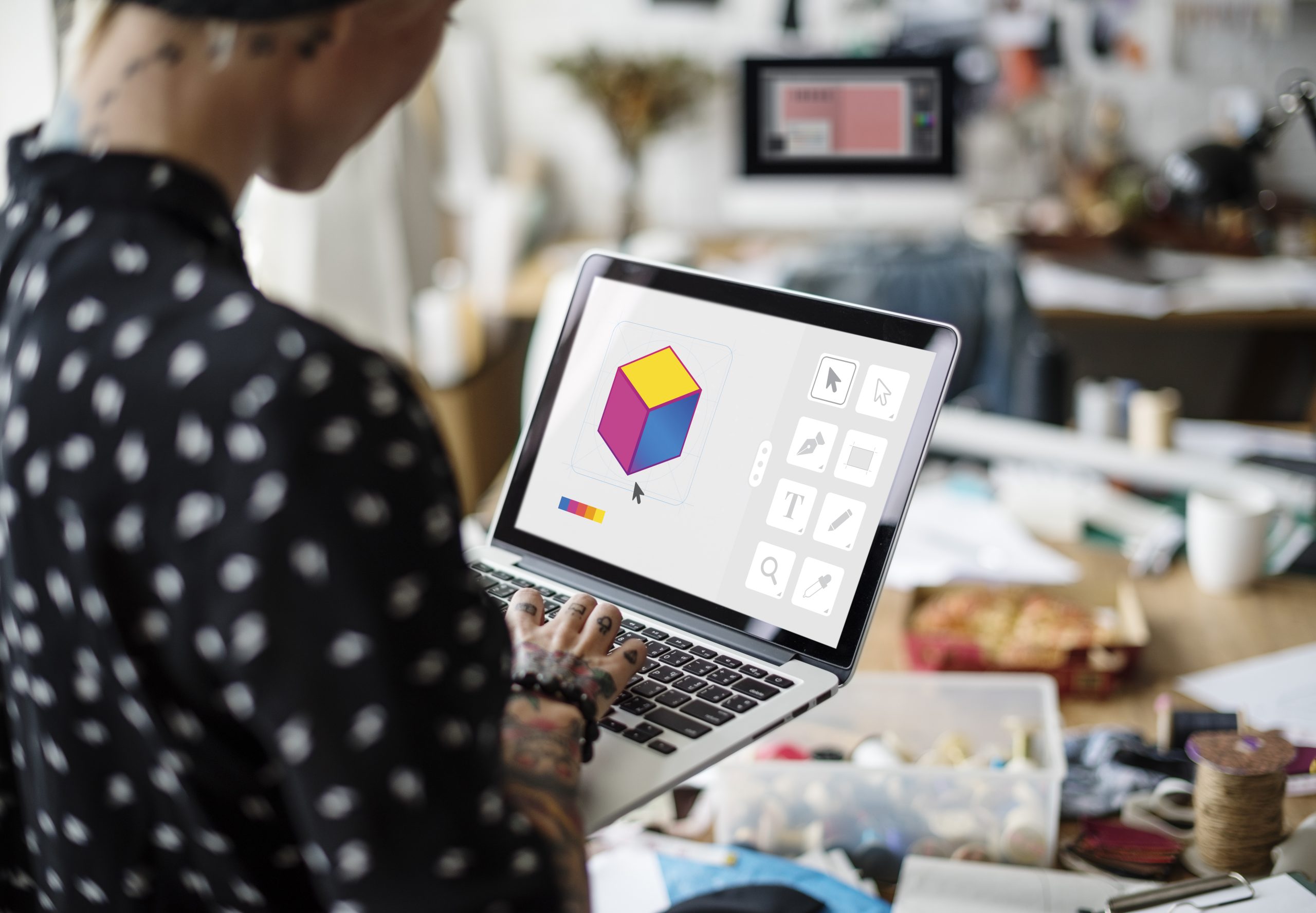 Grafikdesignerin gestaltet ein farbiges Logo-Element am Laptop – Corporate Design für Ihre Branding Agentur Passau