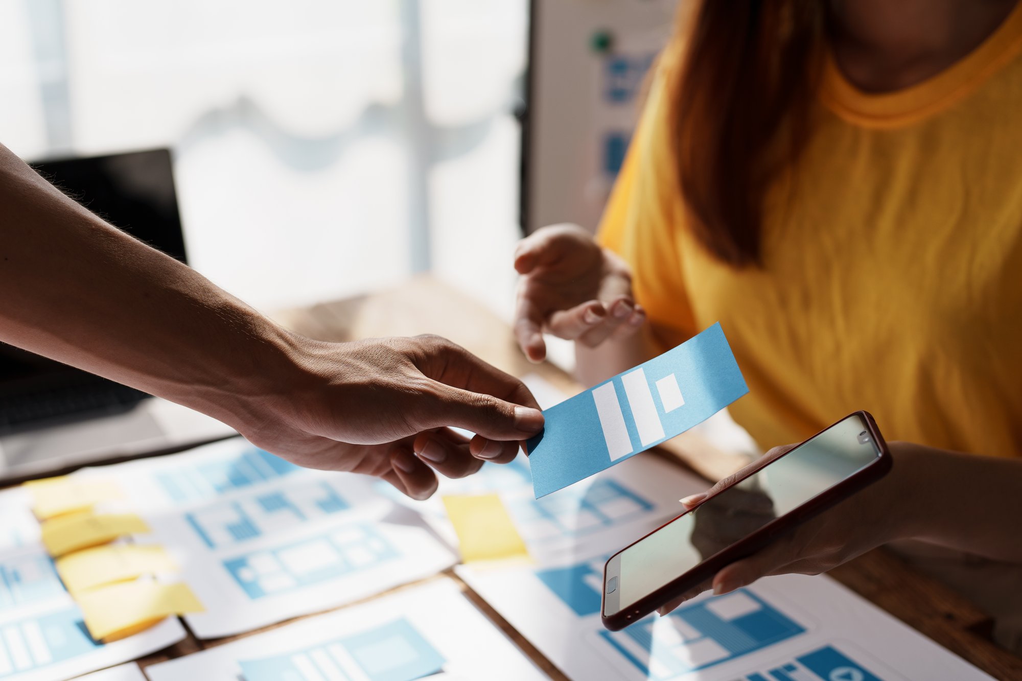 Team bespricht farbige UI-Design-Karten für eine mobile Anwendung