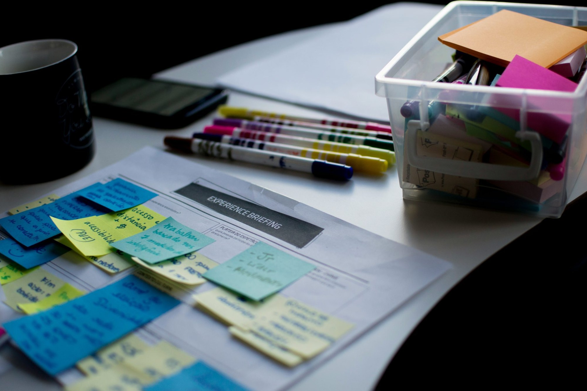 Bunte Klebezettel und Stifte auf einem Experience-Briefing-Dokument