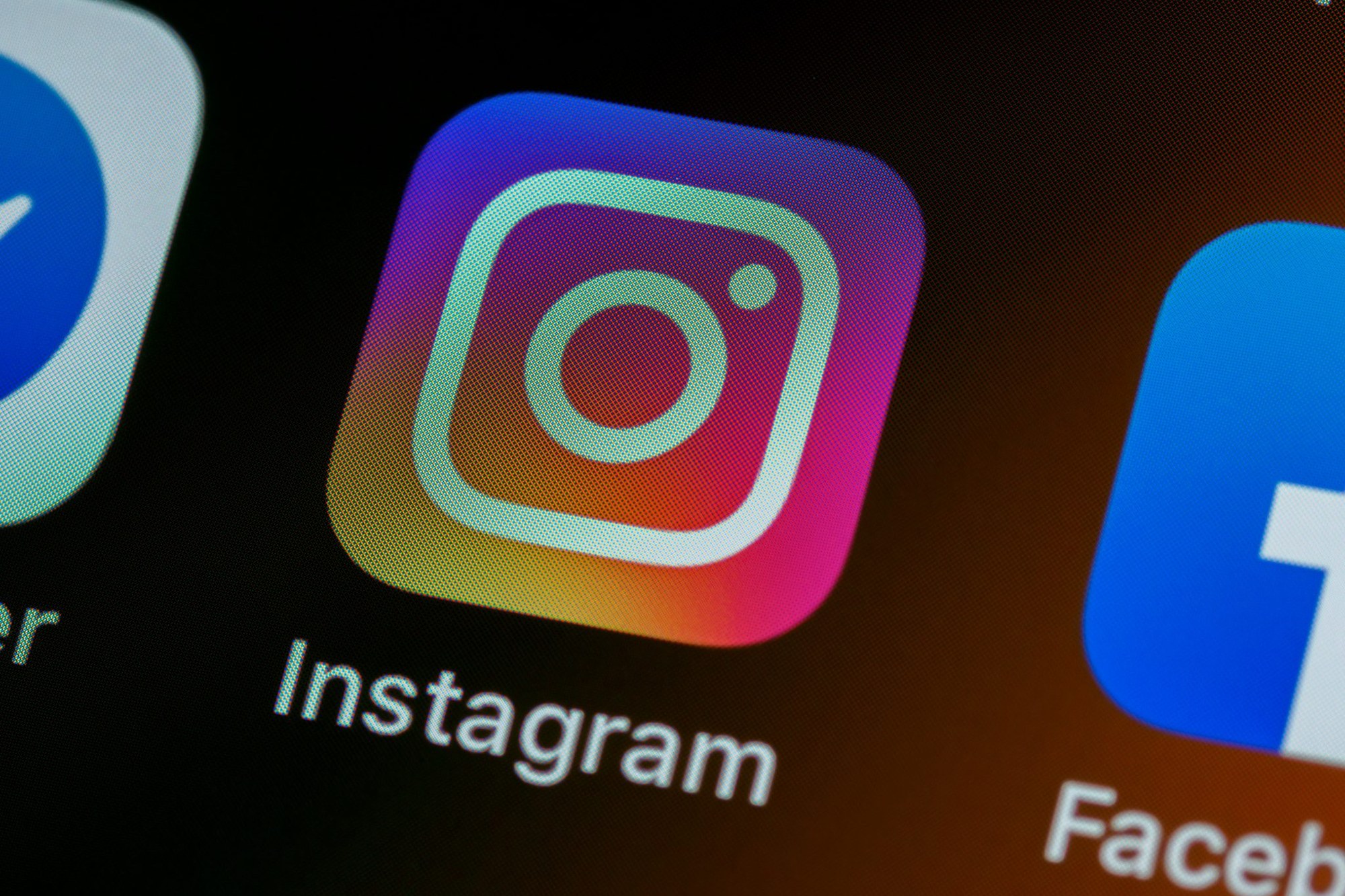 Nahaufnahme des Instagram-App-Symbols neben Facebook auf einem Smartphone-Bildschirm