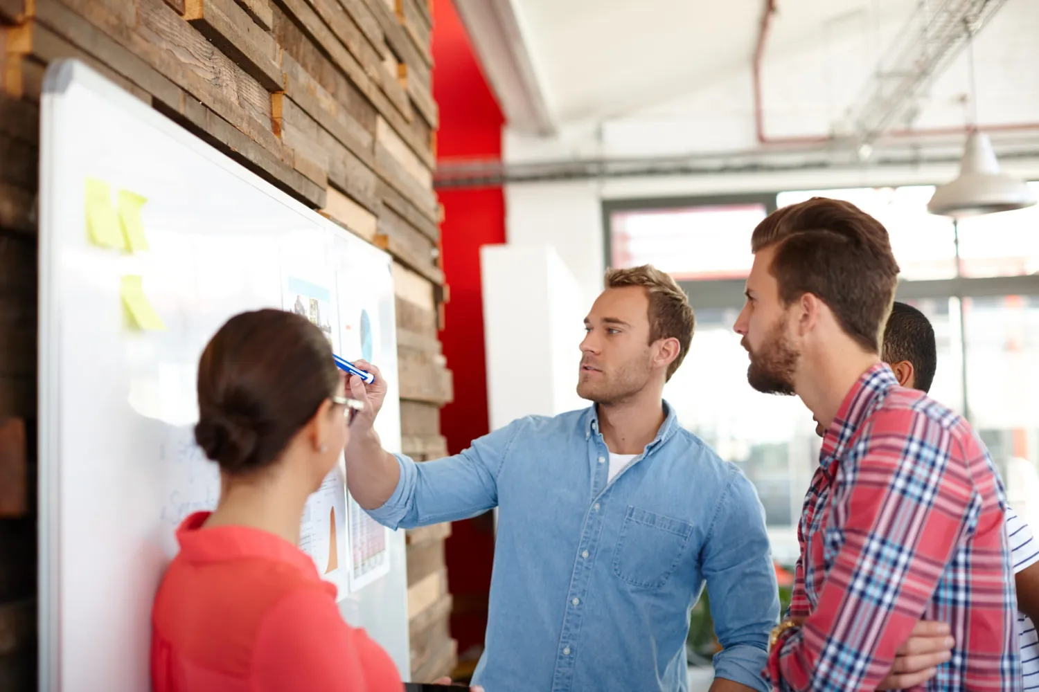 Team plant an einem Whiteboard mit Notizzetteln die Strategie einer B2B-Kampagne